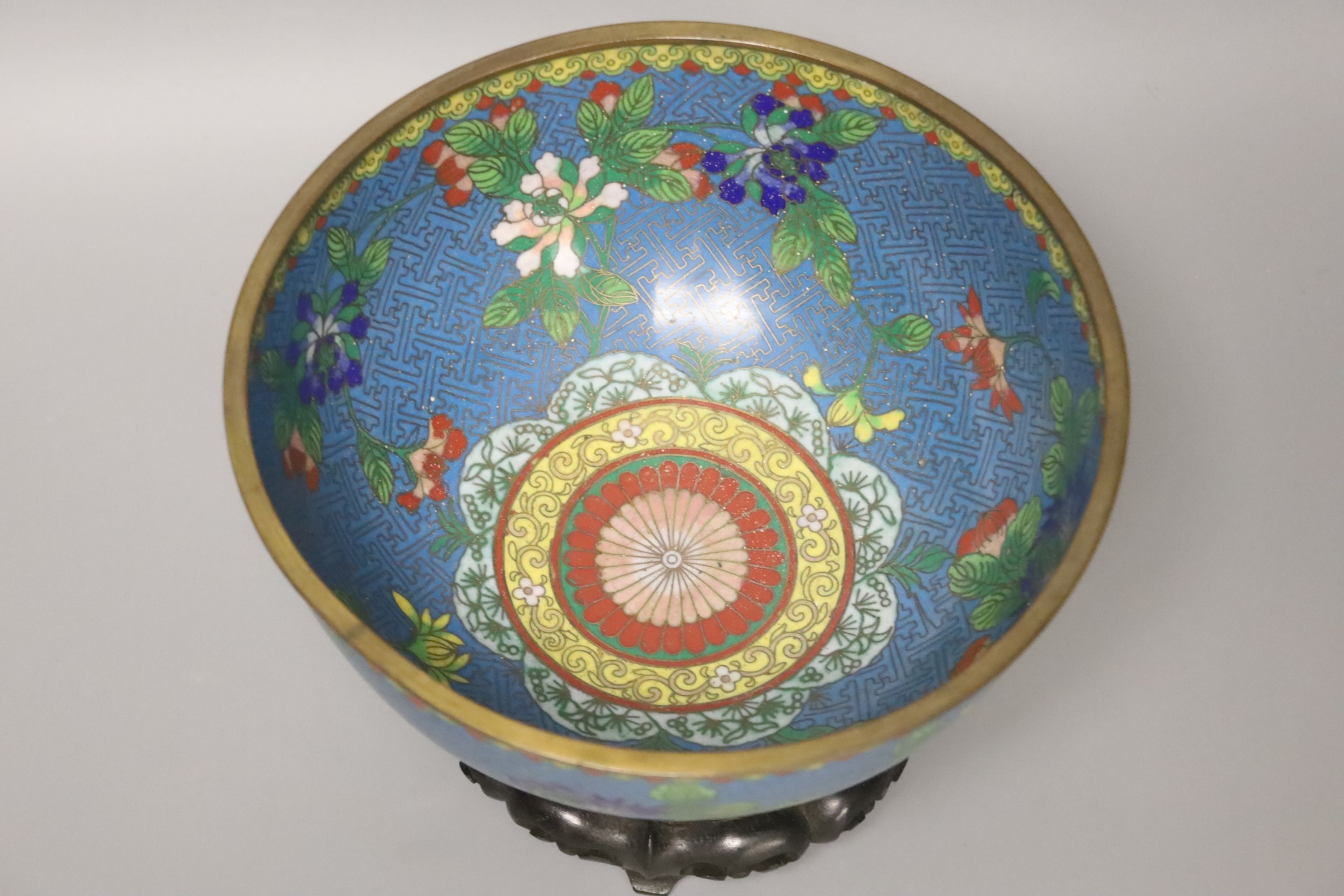 An early 20th century Chinese cloisonne enamel bowl, wood stand 20cm